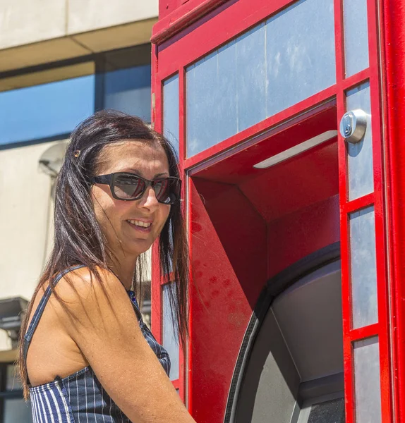 Mulher bonita em Londres cabine telefônica vermelha — Fotografia de Stock