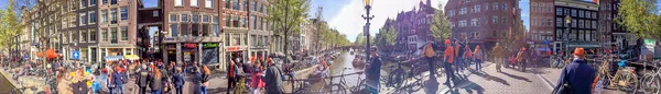 Amsterdam - April 2015: Toeristen lopen langs de stadsstraten. De ci — Stockfoto