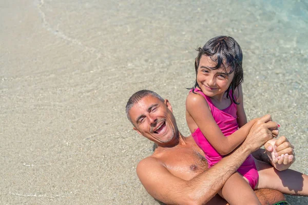 Happy young girl at sea border enjoying life with father — Stock Photo, Image