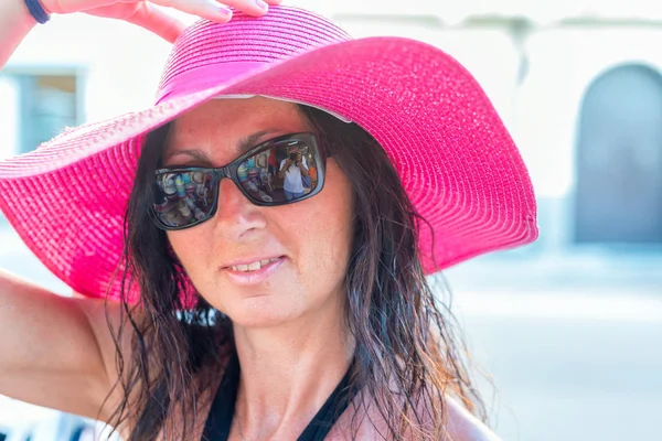 Hermosa mujer con sombrero rosa contra el sol — Foto de Stock