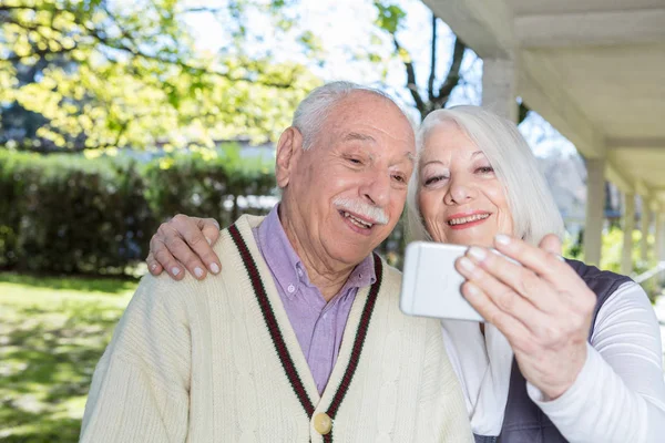 Ηλικιωμένο ζευγάρι κάνοντας selfie στον κήπο — Φωτογραφία Αρχείου