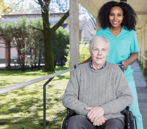 African nurse helping man on the wheelchair