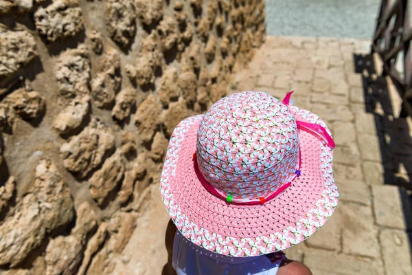 Vista posterior de la joven con sombrero rosa visitando antigua fortaleza — Foto de Stock