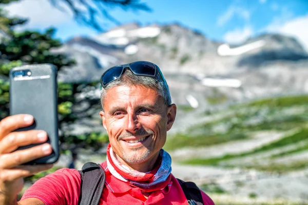 Homem feliz na década de 40 fazendo caminhadas selfie montanha pico — Fotografia de Stock