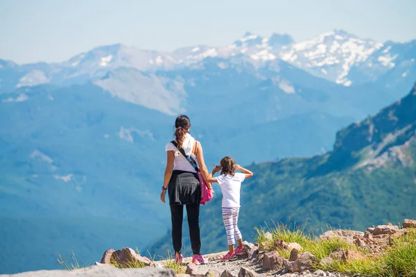 Mãe e filha em um pico de montanha desfrutando de panorama, de volta v — Fotografia de Stock