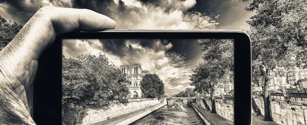 Male hand with smartphone taking a picture of Paris and Notre Da — Stock Photo, Image