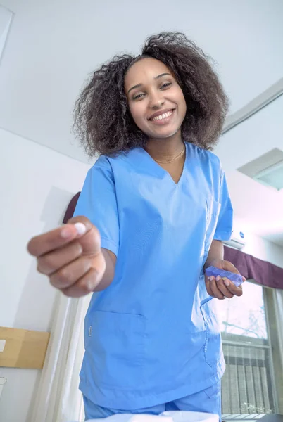 Glücklich afrikanische Krankenschwester lächelnd geben Pille zu Patient im Bett, Aufstand — Stockfoto