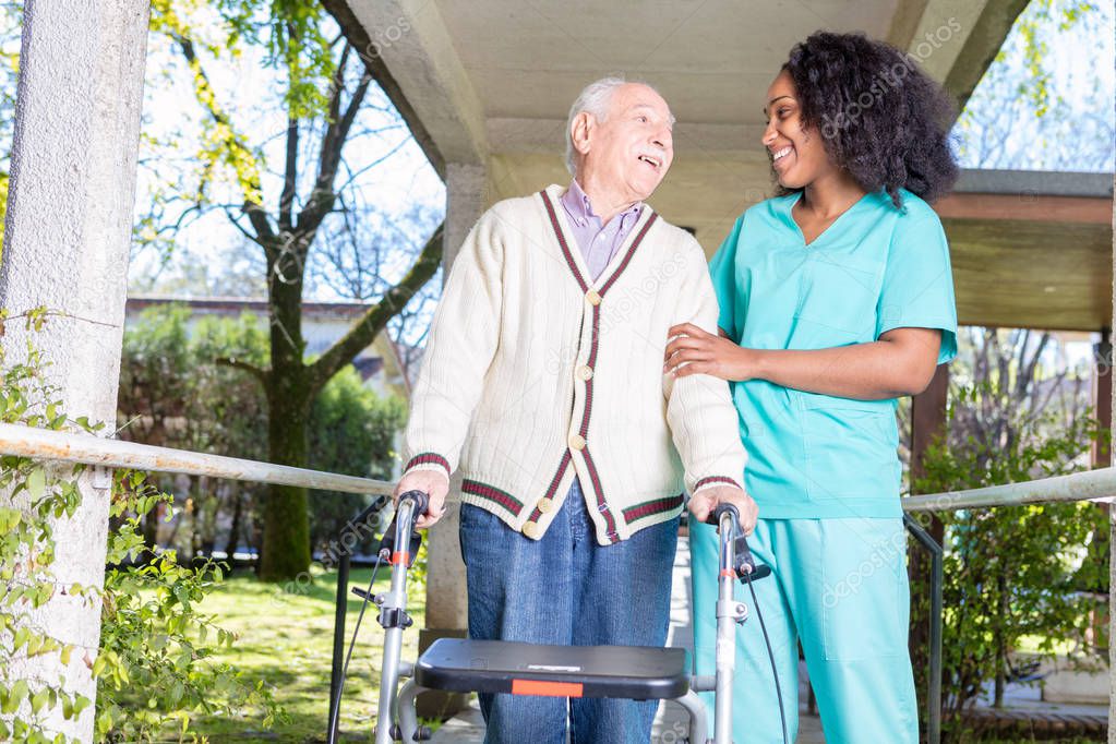 Active elderly retired man outdoor with african nurse