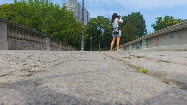 Femme marchant le long des rues de la ville faisant photo — Photo