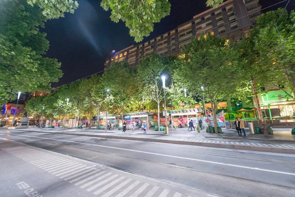 MELBOURNE - OCTUBRE 2015: Los turistas visitan las calles de la ciudad por la noche . — Foto de Stock