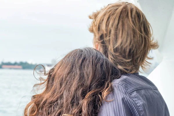 Jovem casal abraçando olhando para o oceano — Fotografia de Stock