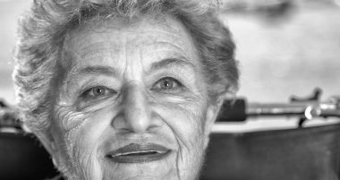 Yaşlı kadın onun tekerlekli sandalye üzerinde gülümseyen açık etkin