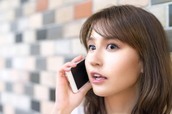 Beautiful asian young girl smiling speaking at the phone — Stock Photo, Image