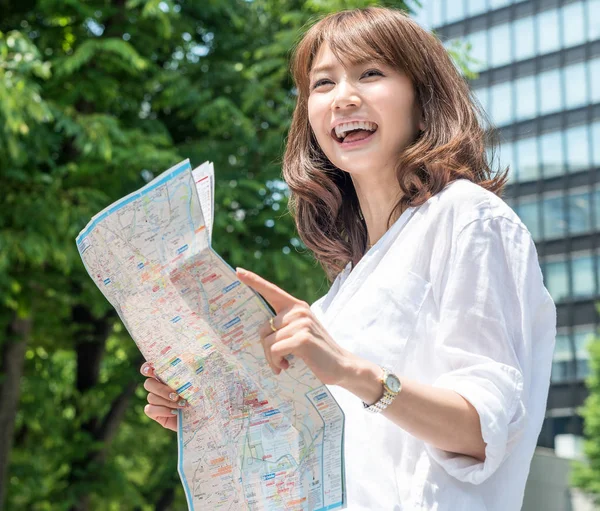 Beautiful asian young girl smiling reading a city map — Stock Photo, Image