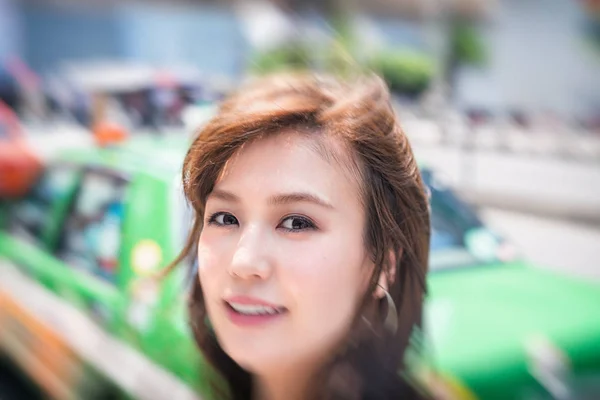 Business asian woman waiting for a taxi in a big city — Stock Photo, Image