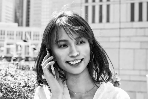 Beautiful asian young girl smiling speaking with smartphone — Stock Photo, Image