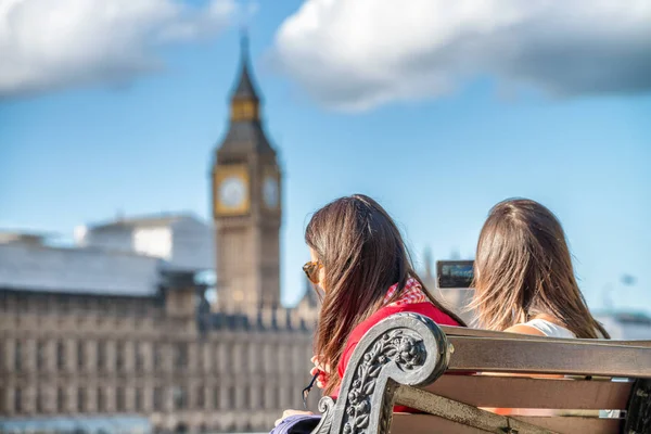 Two female tourists on a bench in front of Westminster Palace, L — Stock Photo, Image