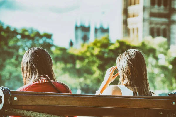 Deux touristes féminines sur un banc devant le palais de Westminster, L — Photo