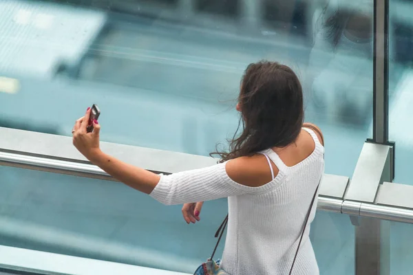 Hermosa chica haciendo selfies en un edificio de la ciudad. Concepto turístico — Foto de Stock