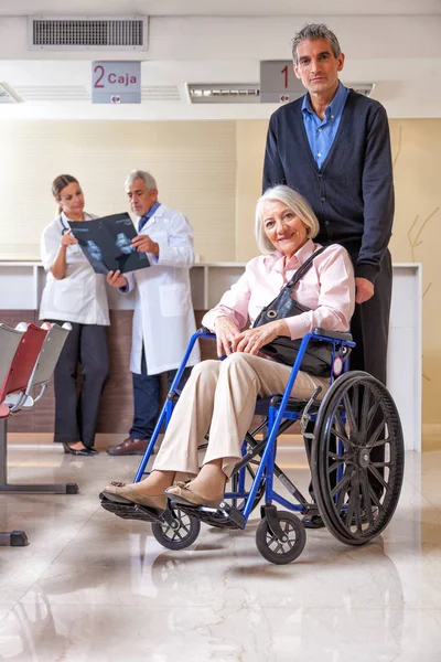 Médico com paciente idosa em cadeira de rodas no hospital — Fotografia de Stock