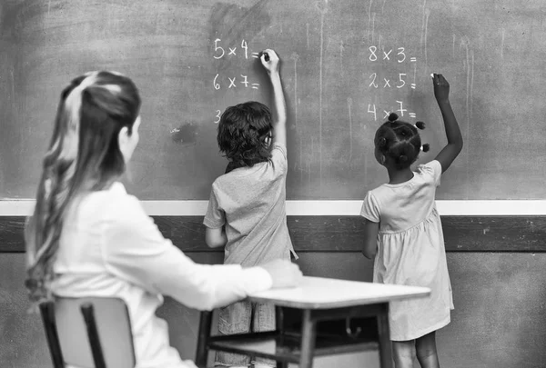 Female teacher in 40s teaching at elementary school — Stock Photo, Image