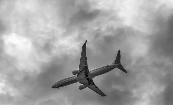 Vliegtuig silhouet tegen bewolkte hemel — Stockfoto