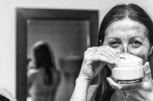 Woman in 40s caring of her beautiful skin on the face standing n — Stock Photo, Image