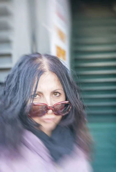 Grimas av kvinna i 40-årsåldern med solglasögon — Stockfoto