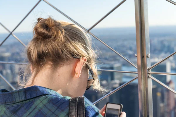 Back view of girl watching mobile city photos — Stock Photo, Image