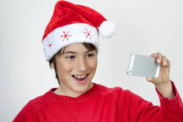 Junge mit Weihnachtsmütze macht glücklich Selfie — Stockfoto