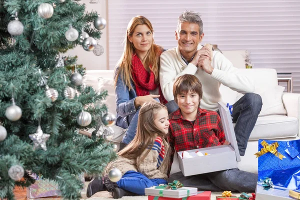 Happy family under Christmas tree at home — Stock Photo, Image