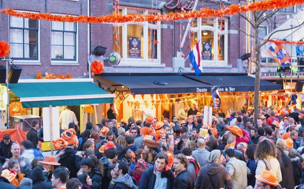Amsterdam - duben 2013: Turisty podél městských ulic. Město na — Stock fotografie