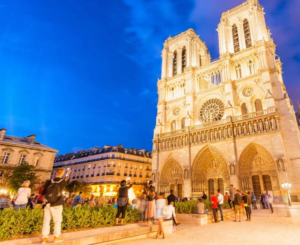 Parijs - juli 2014: Toeristen bezoek kathedraal Notre Dame bij nacht. — Stockfoto