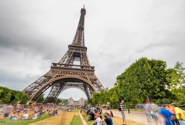 Tourists enjoy Tour Eiffel view from Champs de Mars on a cloudy — Stock Photo, Image