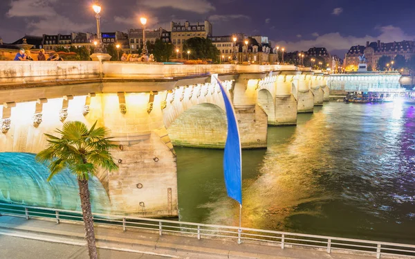 A turisták élvezhetik a Szajna, a párizsi híd éjszakai — Stock Fotó