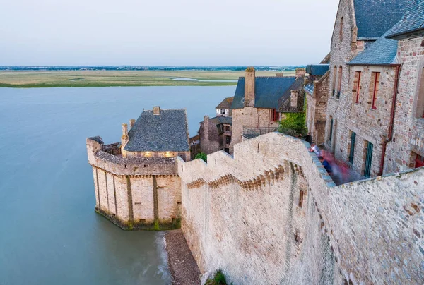 Мон-Сен-Мишель на закате со средневековыми зданиями и морем - О. — стоковое фото
