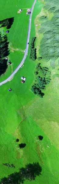 Road across mountain meadows, overhead panoramic aerial view — Stock Photo, Image