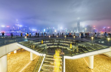 Turistler bak Hong Kong manzarası Kowloon sahil gece