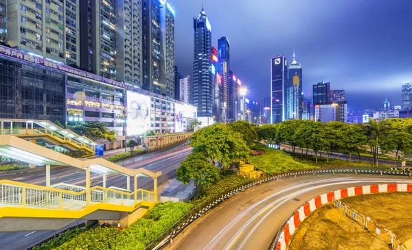 HONG KONG - ABRIL 2014: Rascacielos de la ciudad y trai luz del coche de carretera — Foto de Stock