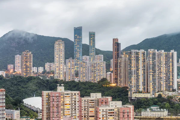 Grattacieli e montagne di Hong Kong al tramonto in una giornata nuvolosa — Foto Stock