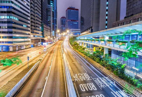 Skyline cidade moderna com trilhas de luz de carro de estrada à noite — Fotografia de Stock