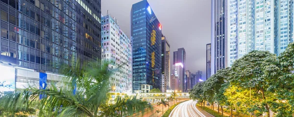 Hong Kong por la noche con la calle de la ciudad y edificios modernos — Foto de Stock