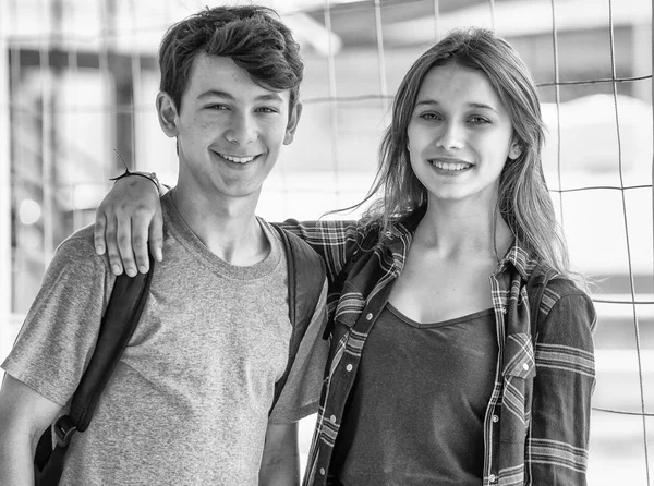 Adolescentes caucasiano casal hapoy sorrindo e abraçando na escola — Fotografia de Stock