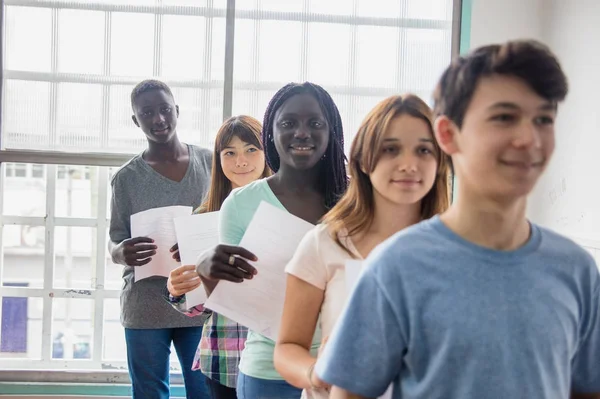 Grupa studentów etniczne multi, stojąc w kolejce, dając ich wor — Zdjęcie stockowe