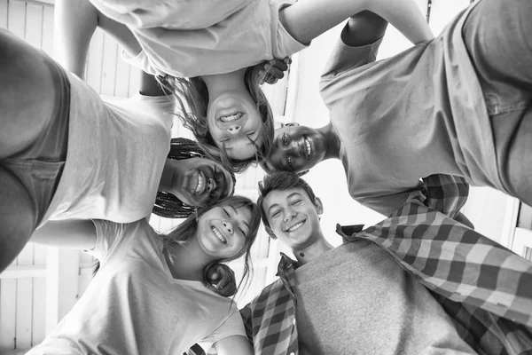 Upward view of happy multi race teenagers looking at camera maki — Stock Photo, Image