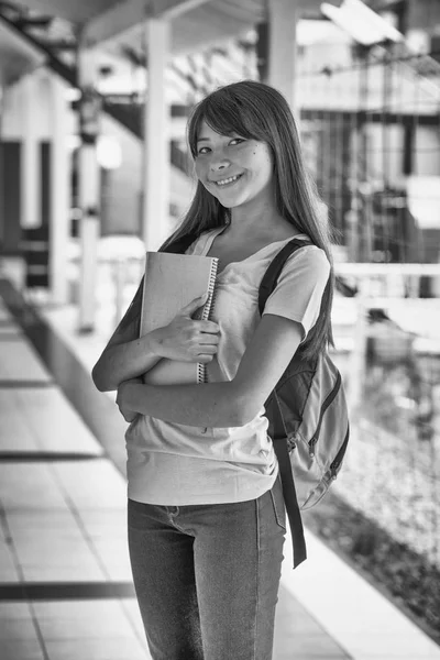 Schoolgirl with copybook in schoolyard — Stock Photo, Image