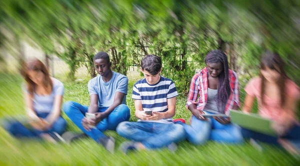 Grupo de sonrientes multirraciales amigos con teléfonos inteligentes, tabletas a —  Fotos de Stock