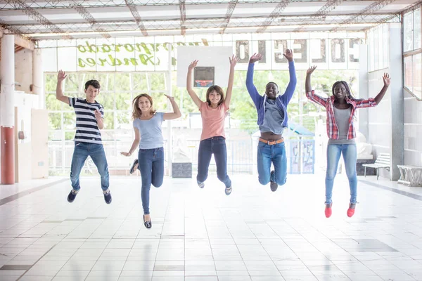 Tonåringar multi etnisk grupp hoppning på skolans innergård. HAPPIN — Stockfoto