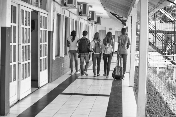 Arkadan görünüşü karışık yarış gençler sınıf schoolyar içinde yürüyüş