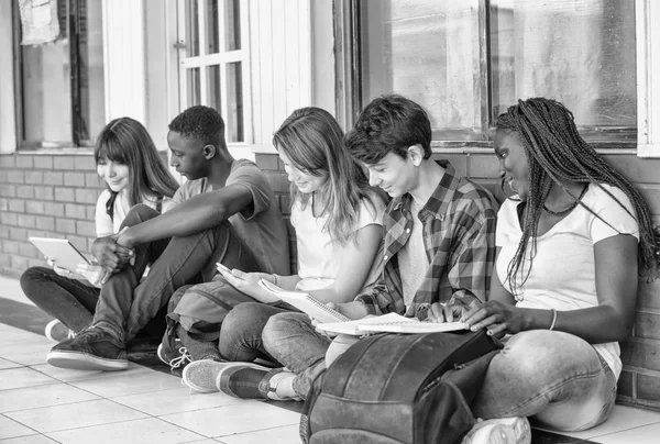 Multi τάξη αγώνα χρησιμοποιώντας βιβλία και δισκία κάθεται σε schoolyar — Φωτογραφία Αρχείου